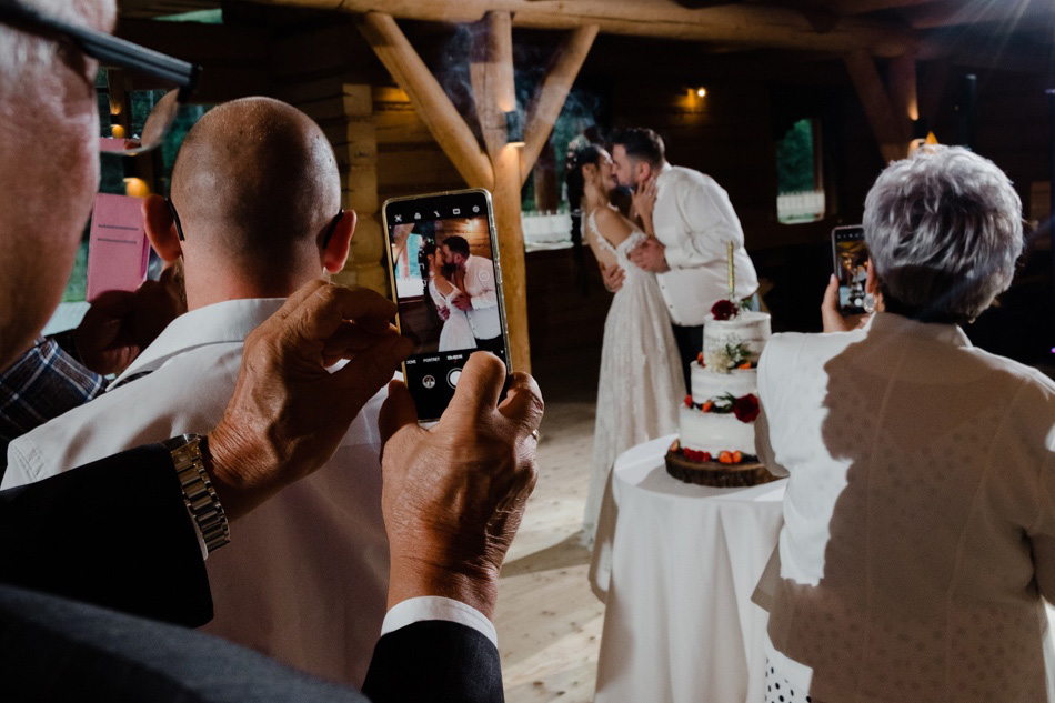 Ciekawe zdjęcia ślubne, tort weselny fotografowany przez gości z telefonami