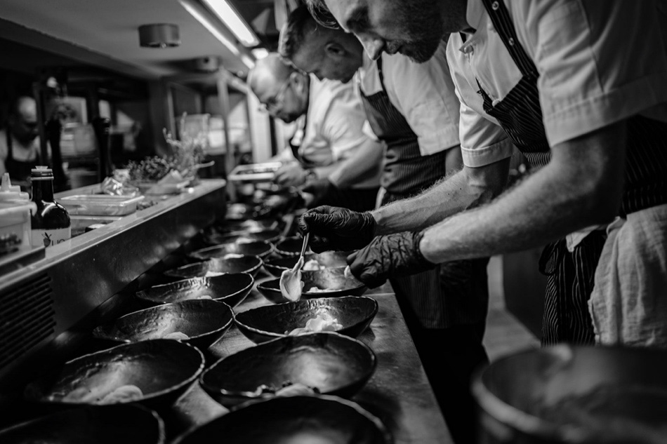 Fotografia kulinarna przedstawiająca kucharzy przygotowywujących dania do wydania w bielskiej ekskluzywnej restauracji Dworek New Restaurant