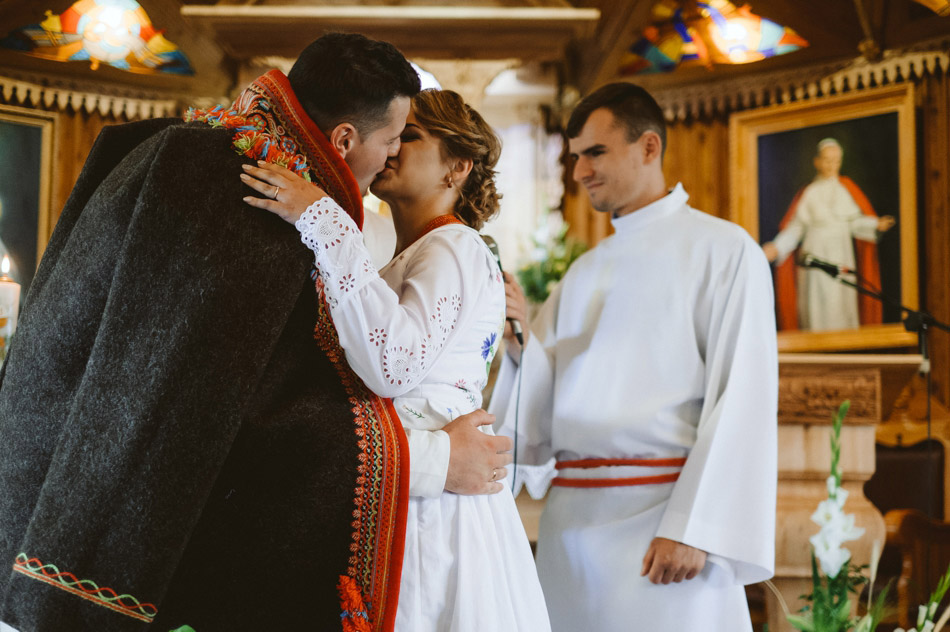 pocałunek pary młodej w kościele po przysiędze ślubnej